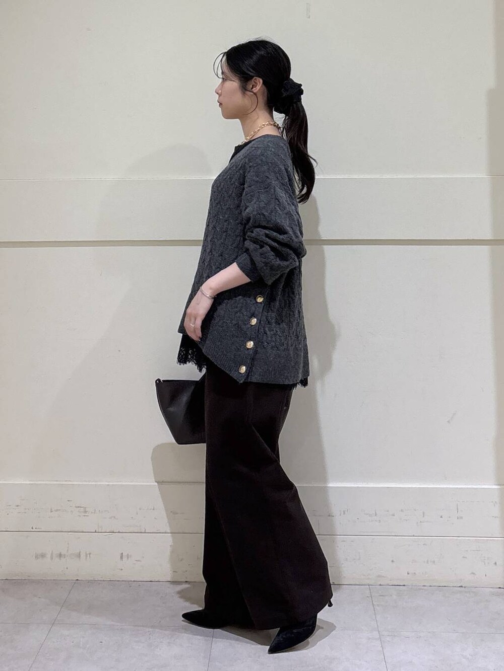 ブラック系のシャツ/ブラウス、グレー系のニット/セーター、ブラウン系のショルダーバッグを着用したレディースの秋コーディネートの2枚目の写真