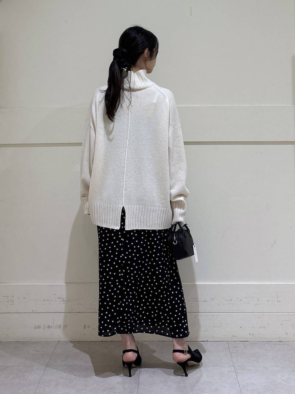 ホワイト系のニット/セーター、グレー系のチェスターコート、ブラウン系のショルダーバッグを着用したレディースの秋コーディネートの7枚目の写真