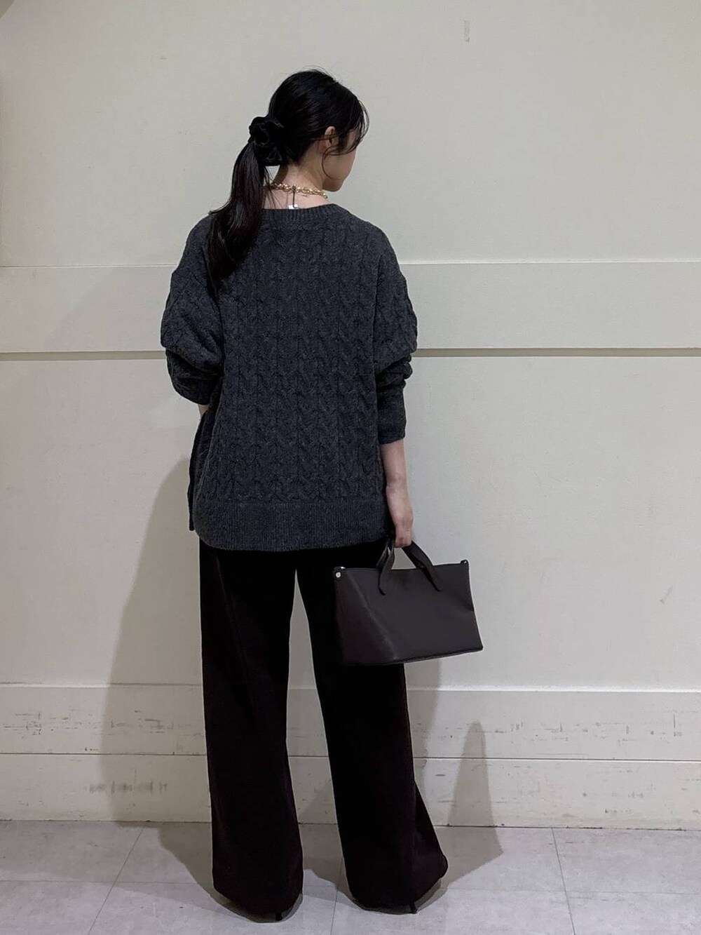ブラック系のシャツ/ブラウス、グレー系のニット/セーター、ブラウン系のショルダーバッグを着用したレディースの秋コーディネートの3枚目の写真
