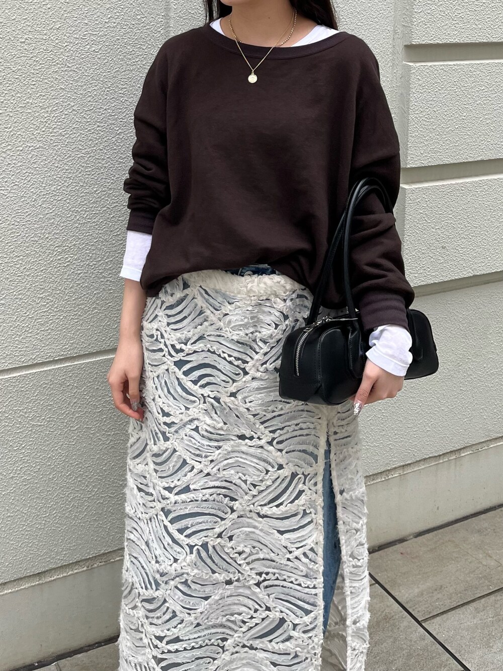 ブラウン系のスウェット、ホワイト系のTシャツ/カットソー、ブラック系のショルダーバッグを着用したレディースの秋コーディネートの4枚目の写真