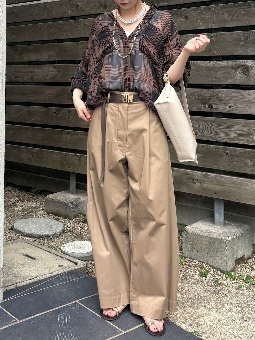 ブラック系のシャツ/ブラウス、ベージュ系のその他パンツ、ホワイト系のショルダーバッグを着用したレディースの夏コーディネートの3枚目の写真