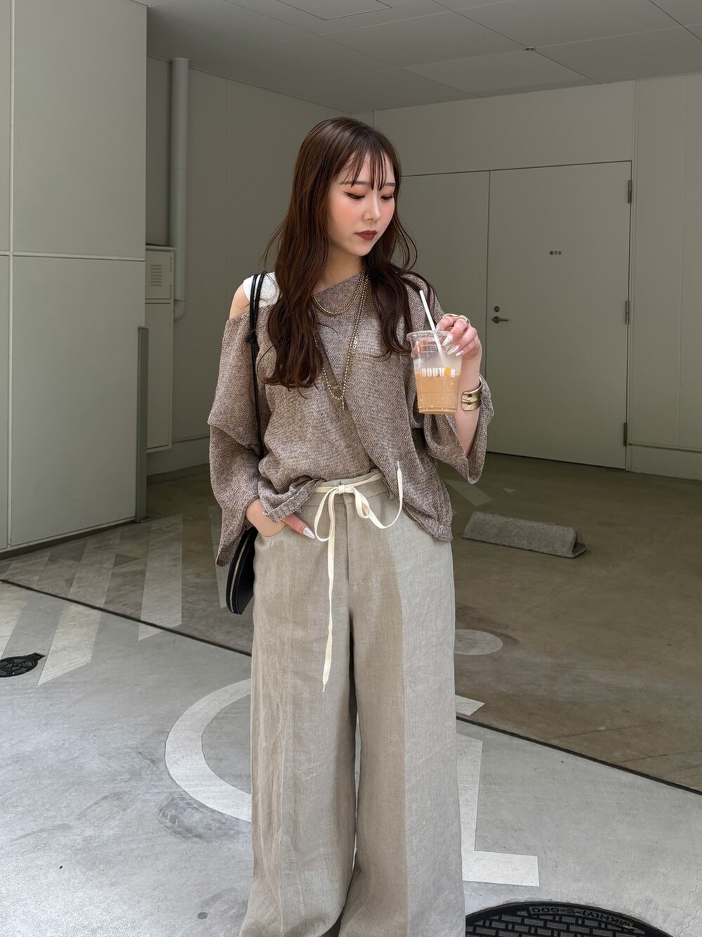 ベージュ系のその他パンツ、ベージュ系のニット/セーター、ブラック系のショルダーバッグを着用したレディースの春コーディネートの3枚目の写真