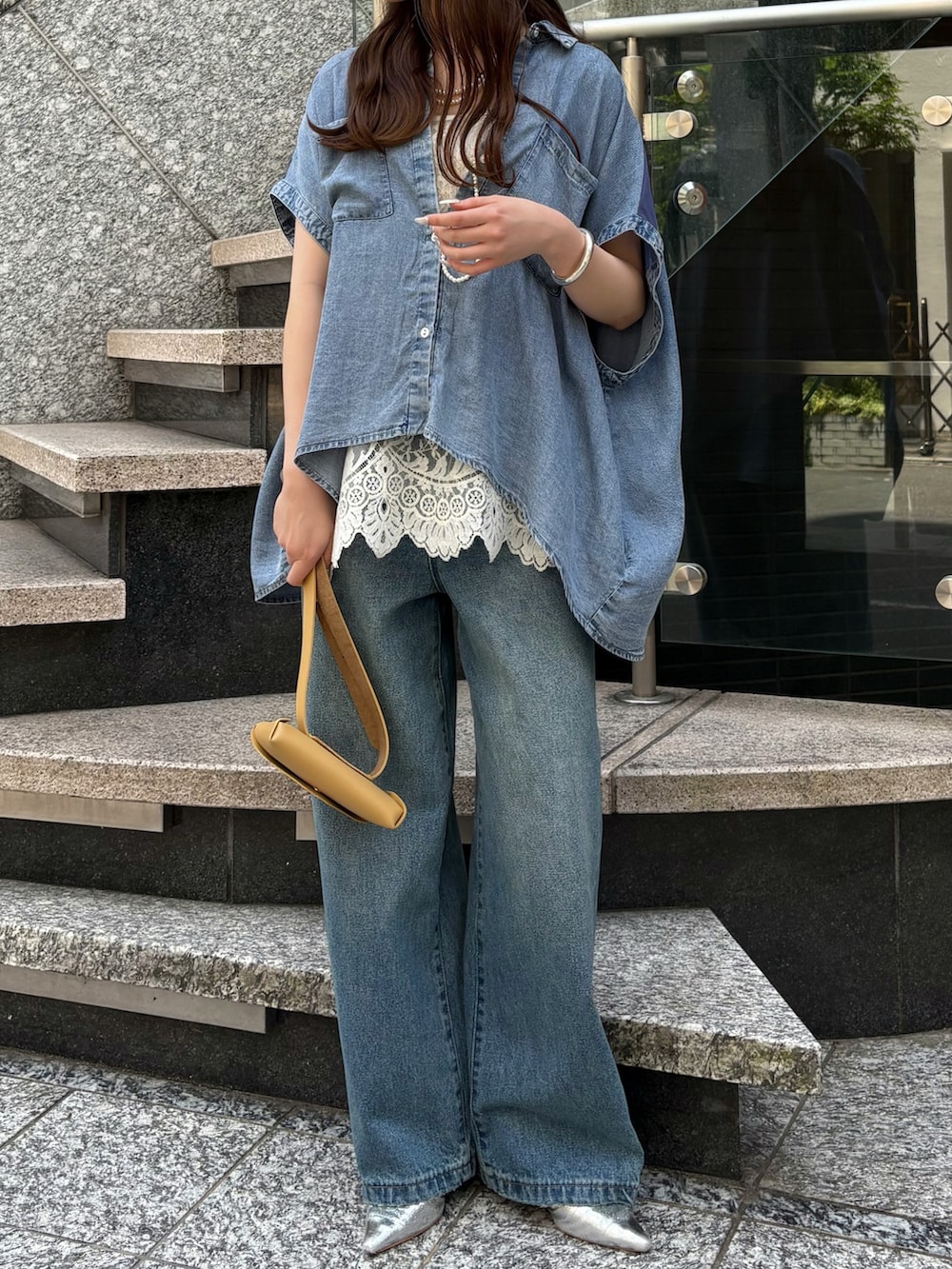ブルー系のデニムパンツ、ホワイト系のシャツ/ブラウス、イエロー系のショルダーバッグを着用したレディースの春コーディネートの3枚目の写真
