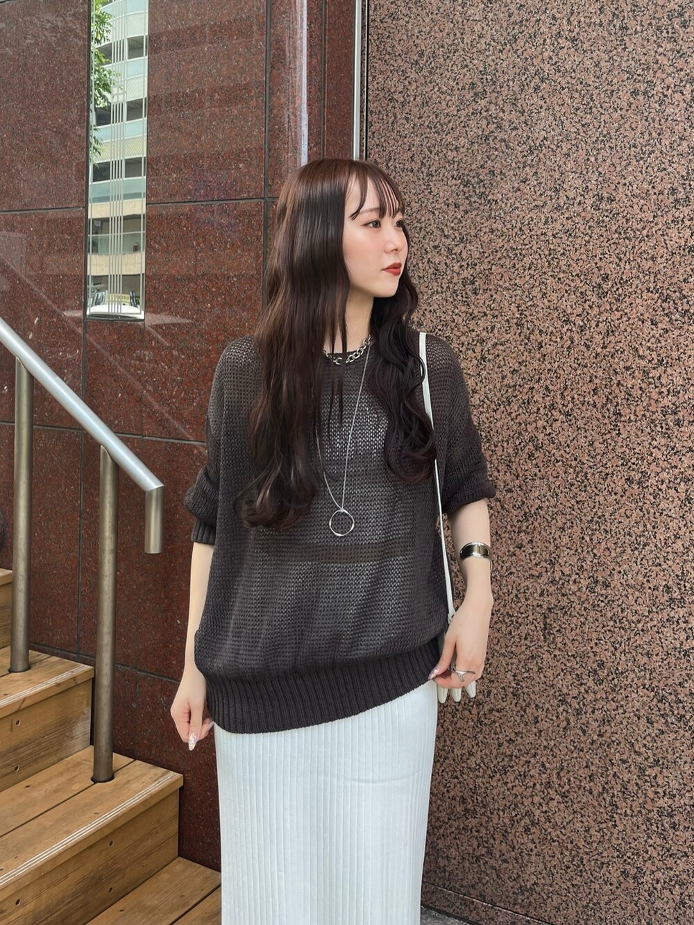 ブラウン系のニット/セーター、ホワイト系のスカート、シルバー系のサンダルを着用したレディースの夏コーディネートの5枚目の写真