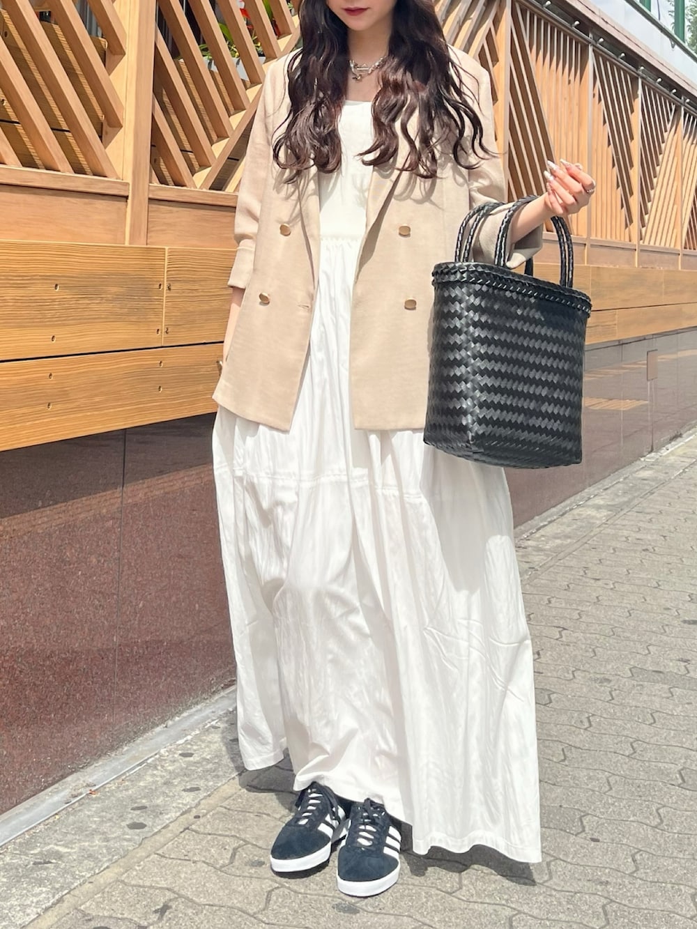 ベージュ系のテーラードジャケット、ホワイト系のワンピース、ブラック系のかごバッグを着用したレディースの夏コーディネートの5枚目の写真