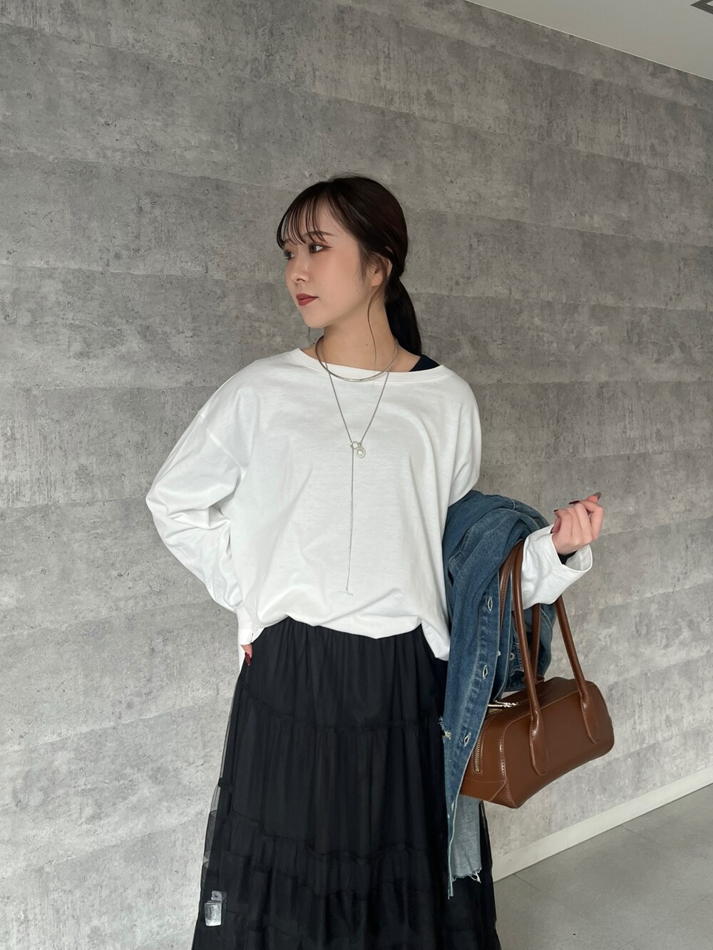 ブラック系のスカート、ブラウン系のショルダーバッグ、ホワイト系のTシャツ/カットソーを着用したレディースの冬コーディネートの3枚目の写真