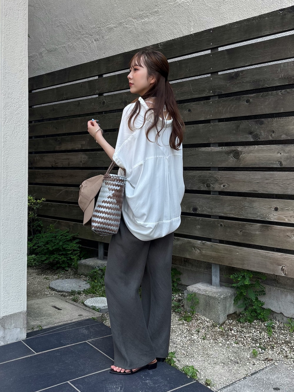 グレー系のその他パンツ、ブラック系のサンダル、ホワイト系のシャツ/ブラウスを着用したレディースの夏コーディネートの3枚目の写真