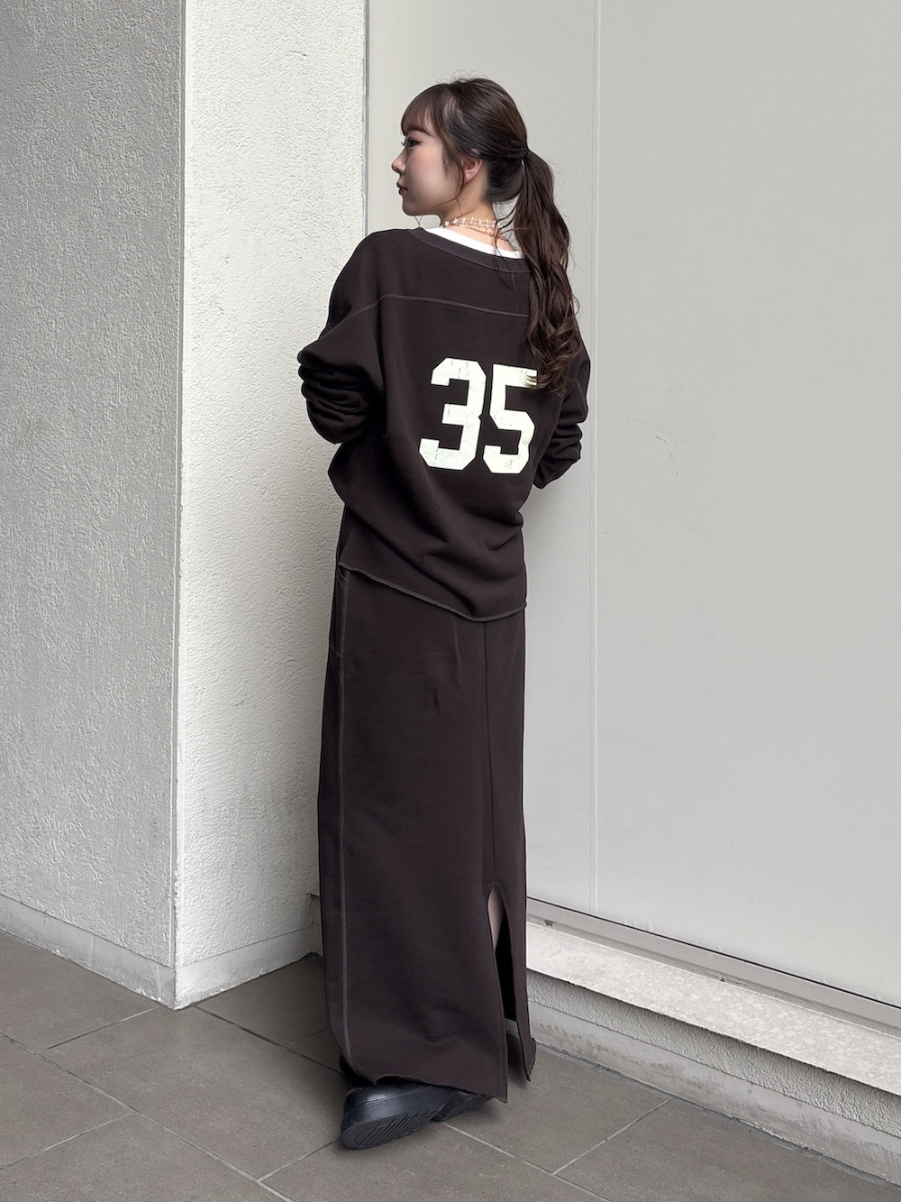 ブラウン系のスカート、イエロー系のショルダーバッグ、ブラウン系のスウェットを着用したレディースの秋コーディネートの2枚目の写真