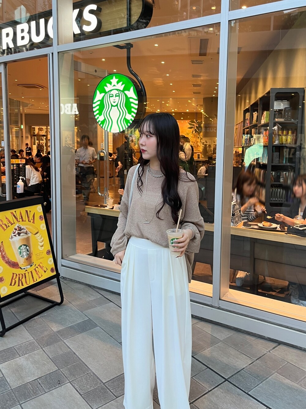 ブラウン系のニット/セーター、ホワイト系のスラックス、シルバー系のパンプスを着用したレディースの夏コーディネートの4枚目の写真