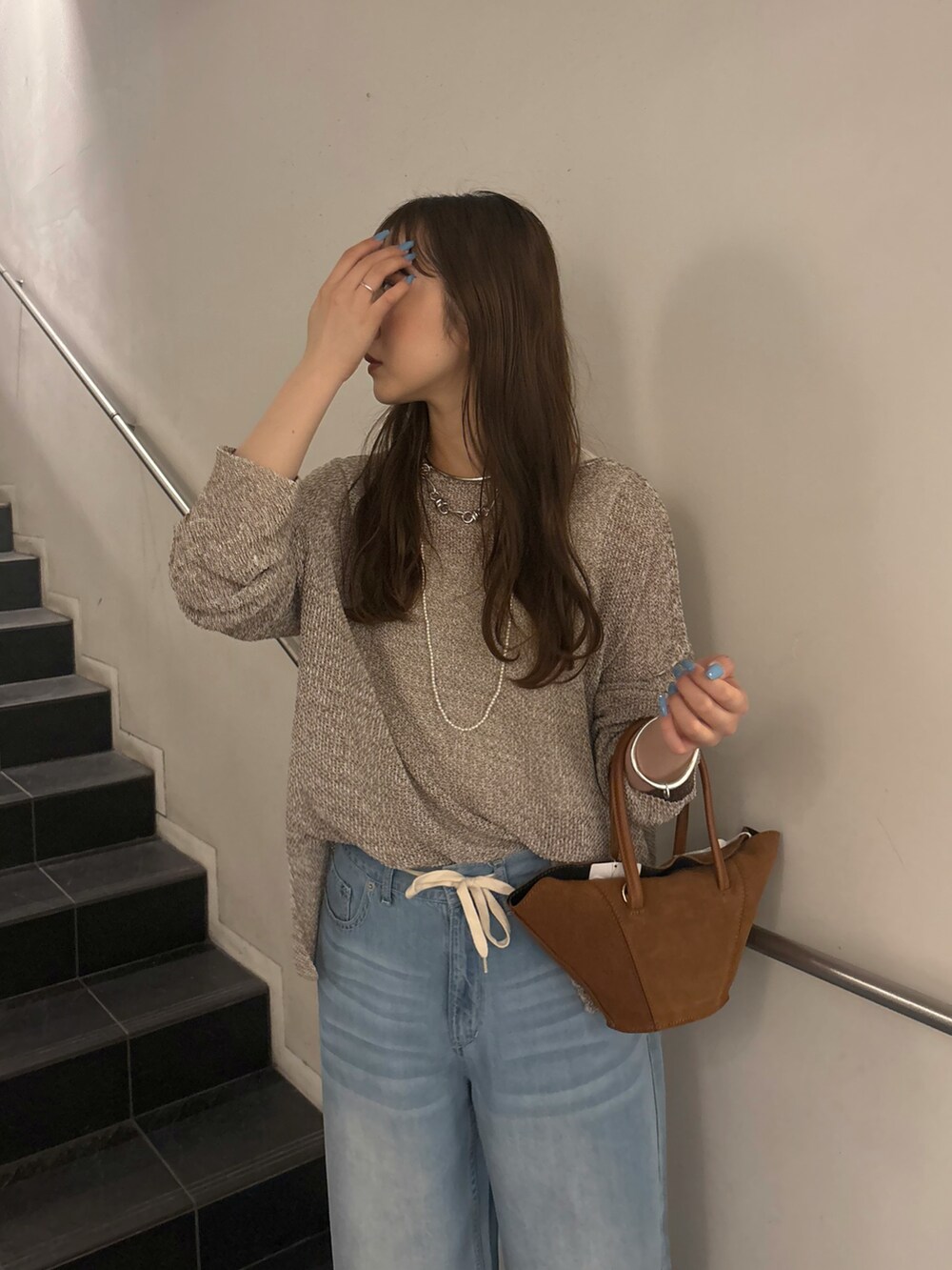 ブルー系のデニムパンツ、ブラック系のサンダル、ベージュ系のニット/セーターを着用したレディースの夏コーディネートの5枚目の写真