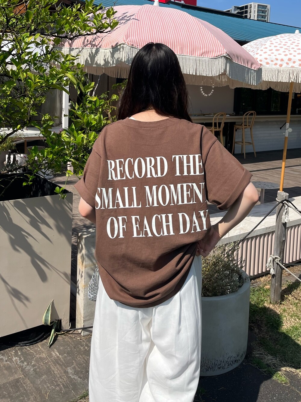 ブラウン系のTシャツ/カットソー、ホワイト系のパンツ、シルバー系のサンダルを着用したレディースの夏コーディネートの3枚目の写真