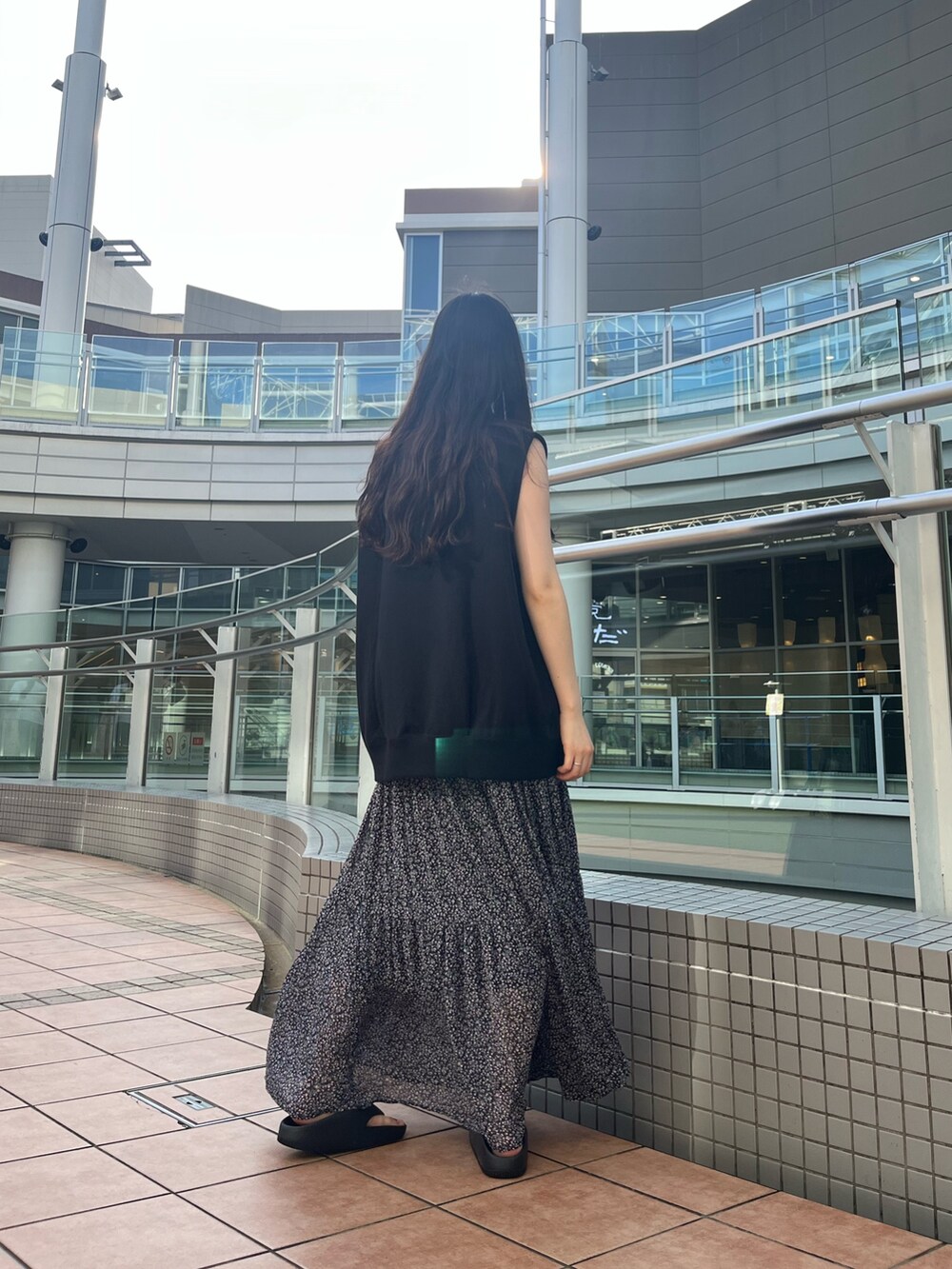 ブラック系のスウェット、ピンク系のスカート、ブラック系のバッグを着用したレディースの夏コーディネートの4枚目の写真