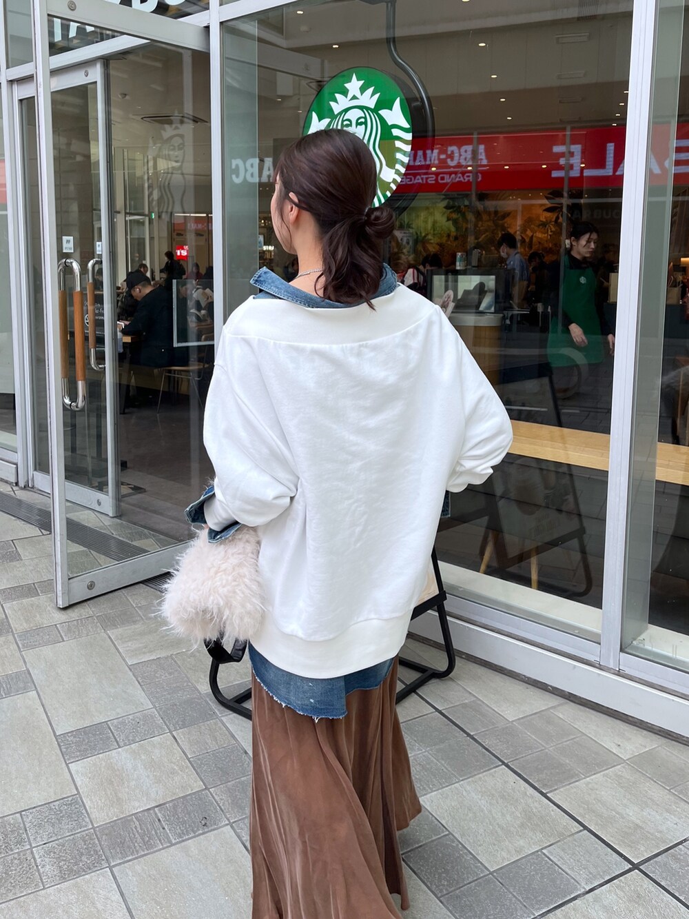 ブラウン系のスカート、ブラック系のブーツ、ホワイト系のTシャツ/カットソーを着用したレディースの冬コーディネートの5枚目の写真