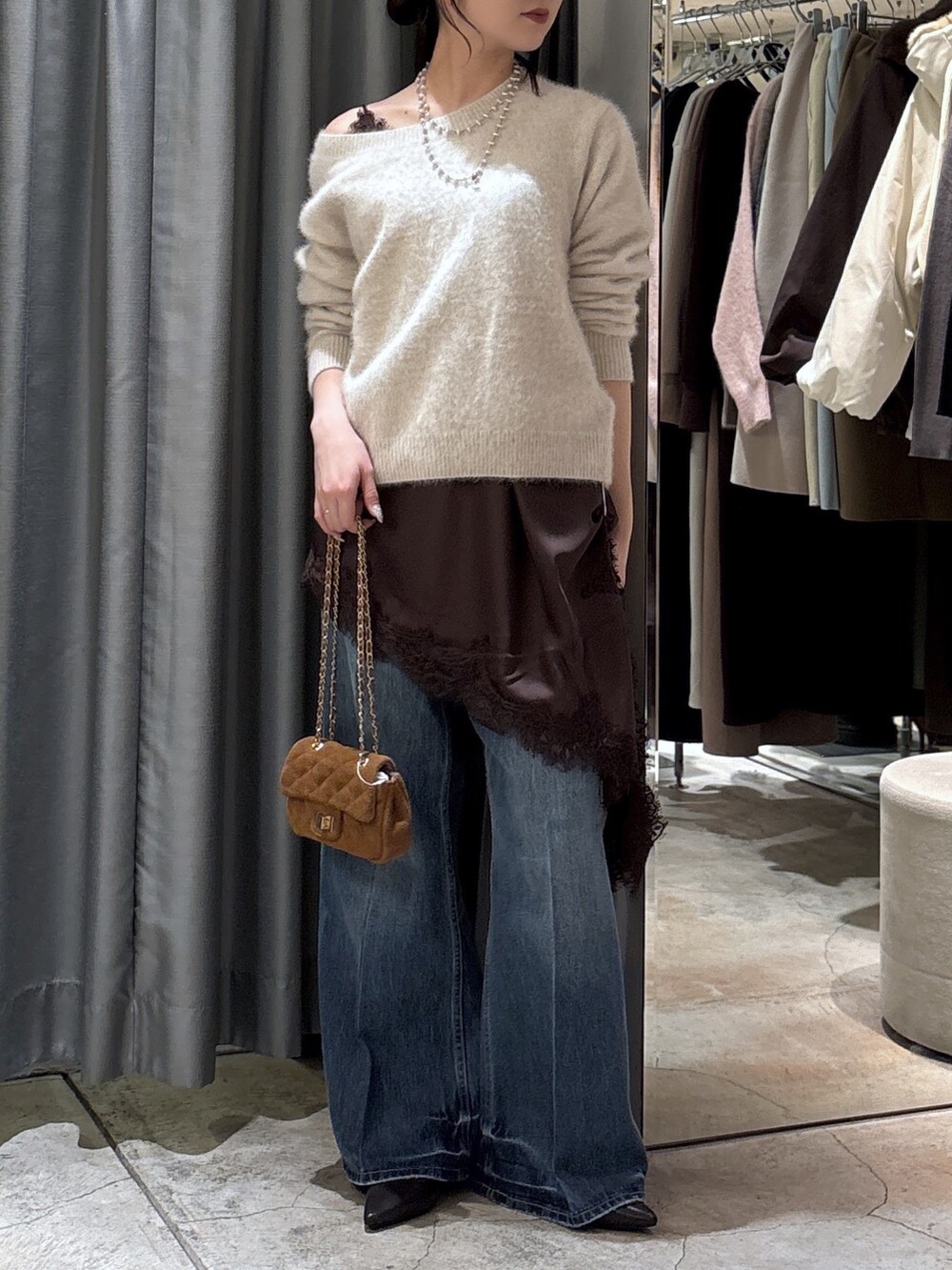 ホワイト系のカーディガン/ボレロ、ブラウン系のキャミソール、ブラウン系のパンプスを着用したレディースの冬コーディネートの2枚目の写真