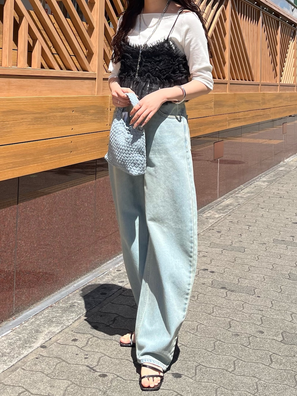 ブルー系のデニムパンツ、ブラック系のキャミソール、ホワイト系のTシャツ/カットソーを着用したレディースの夏コーディネートの3枚目の写真