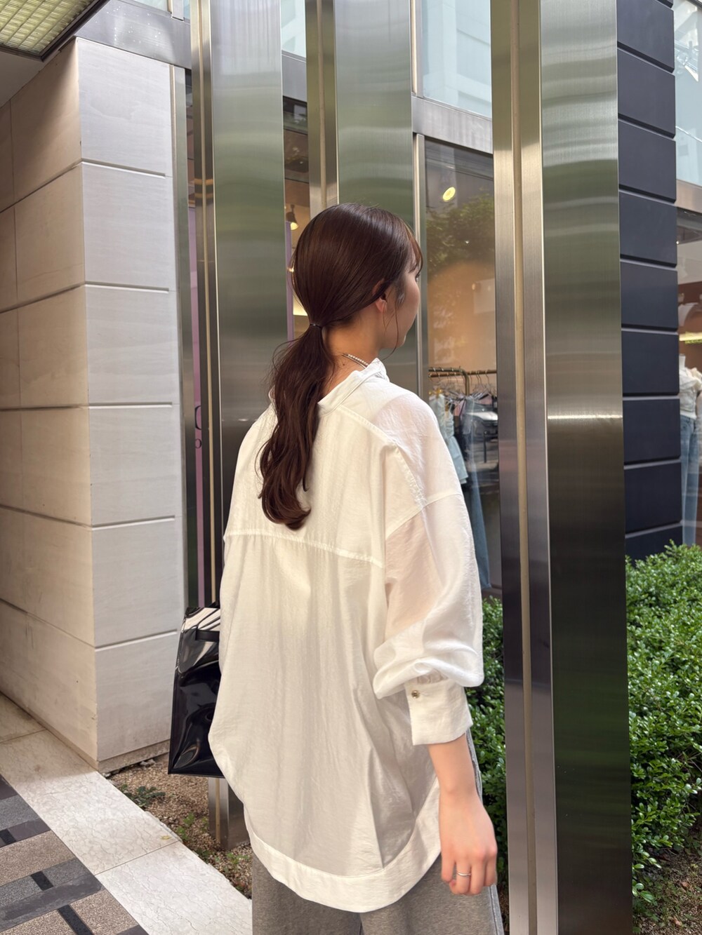 グレー系のその他パンツ、ブラック系のショルダーバッグ、ホワイト系のシャツ/ブラウスを着用したレディースの春コーディネートの4枚目の写真