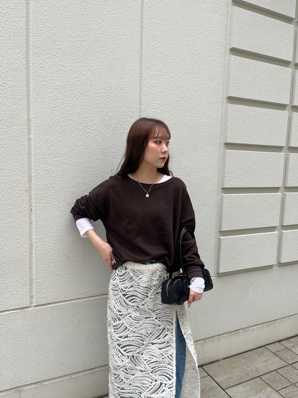 ブラウン系のスウェット、ホワイト系のTシャツ/カットソー、ブラック系のショルダーバッグを着用したレディースの秋コーディネートの3枚目の写真