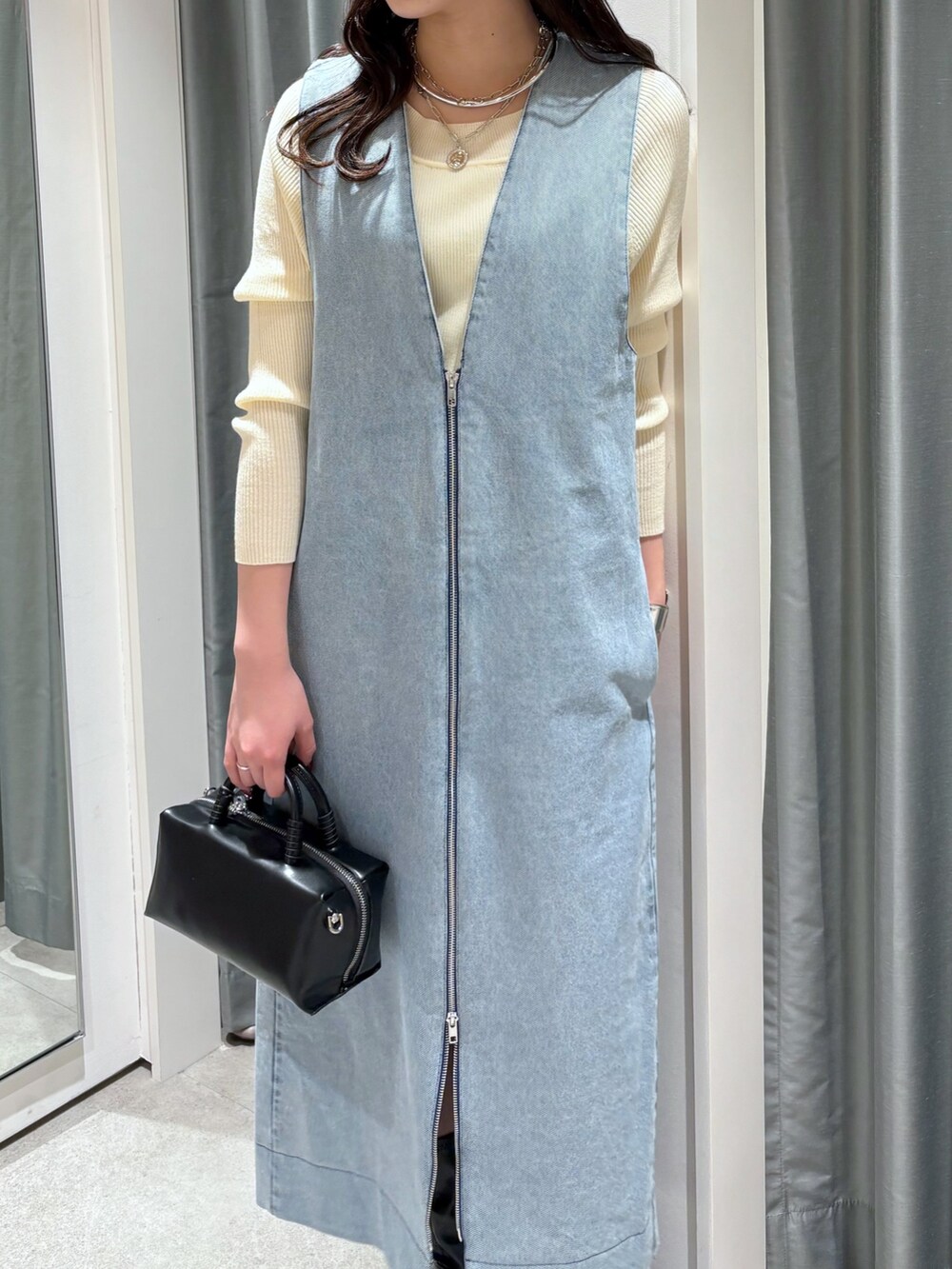 ブルー系のワンピース、ブラック系のショルダーバッグ、ホワイト系のニット/セーターを着用したレディースの冬コーディネートの4枚目の写真