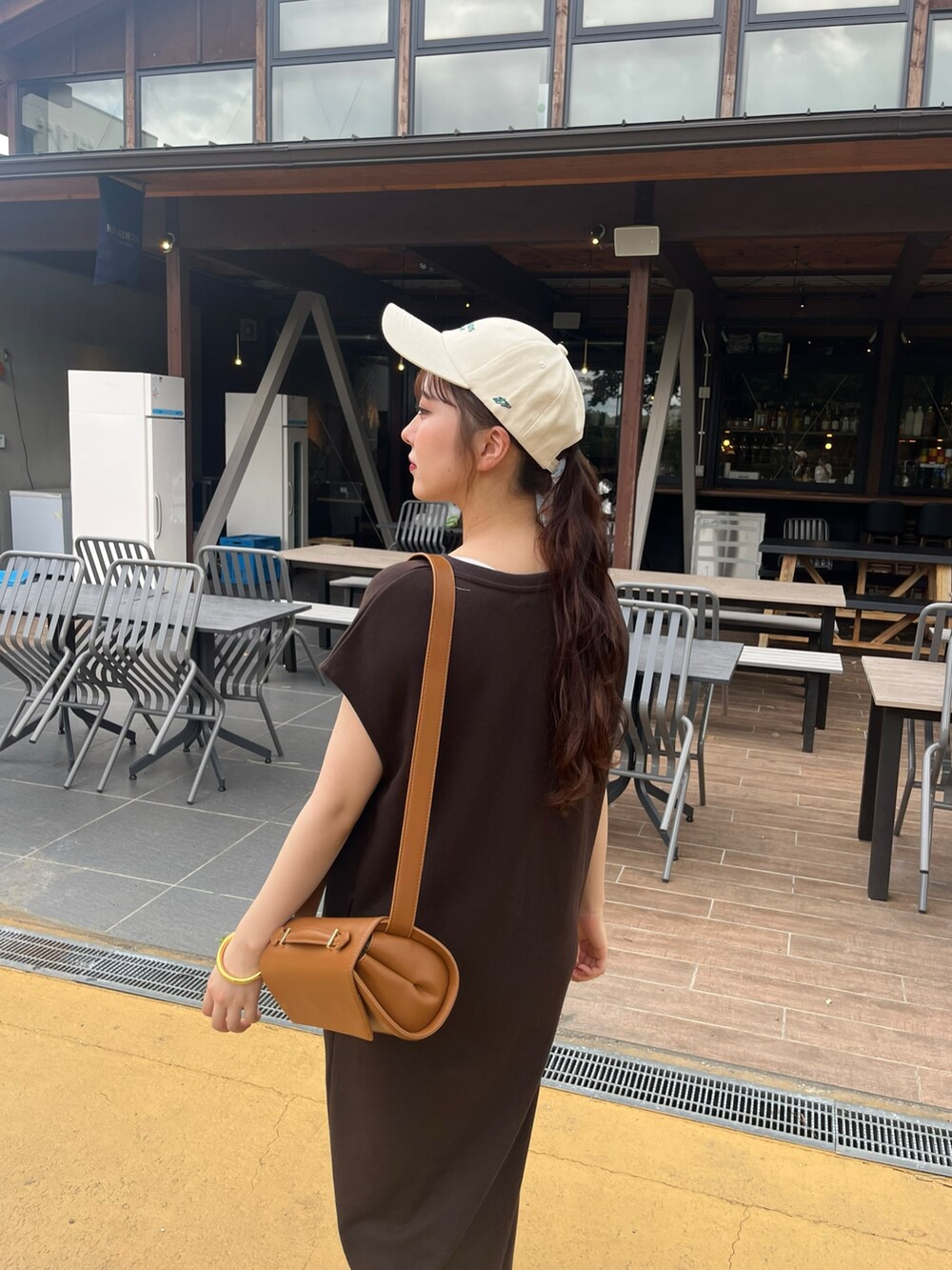 ブラウン系のワンピース、ブラック系のシューズ、ブラウン系のショルダーバッグを着用したレディースの秋コーディネートの6枚目の写真