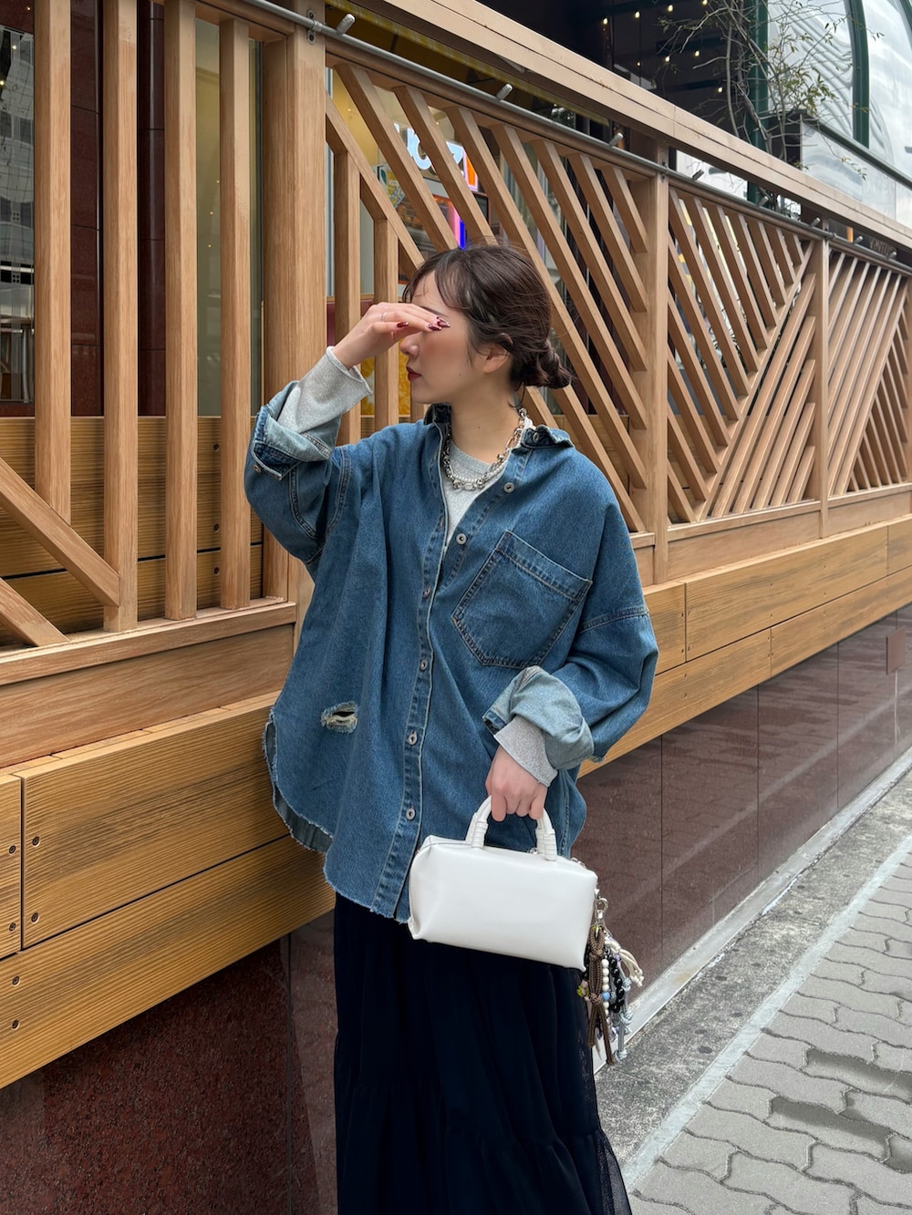 ブルー系のスカート、ブラウン系のブーツ、ホワイト系のショルダーバッグを着用したレディースの冬コーディネートの2枚目の写真