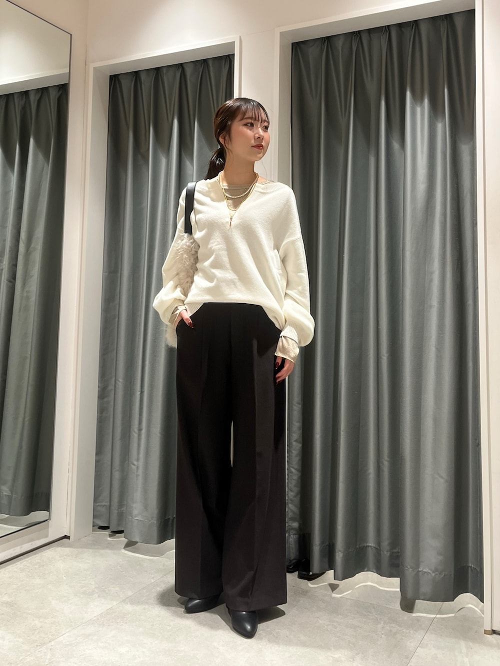 ホワイト系のニット/セーター、ゴールド系のTシャツ/カットソー、ブラウン系のその他パンツを着用したレディースの冬コーディネートの3枚目の写真