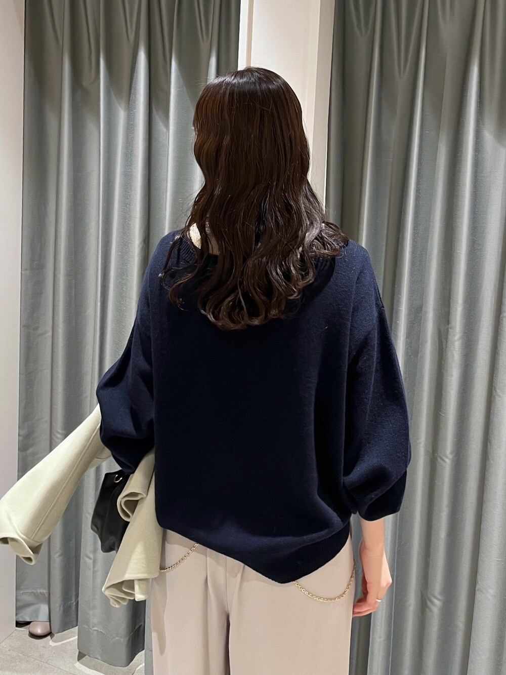 グレー系のスラックス、ブルー系のニット/セーター、グリーン系のその他アウターを着用したレディースの冬コーディネートの4枚目の写真