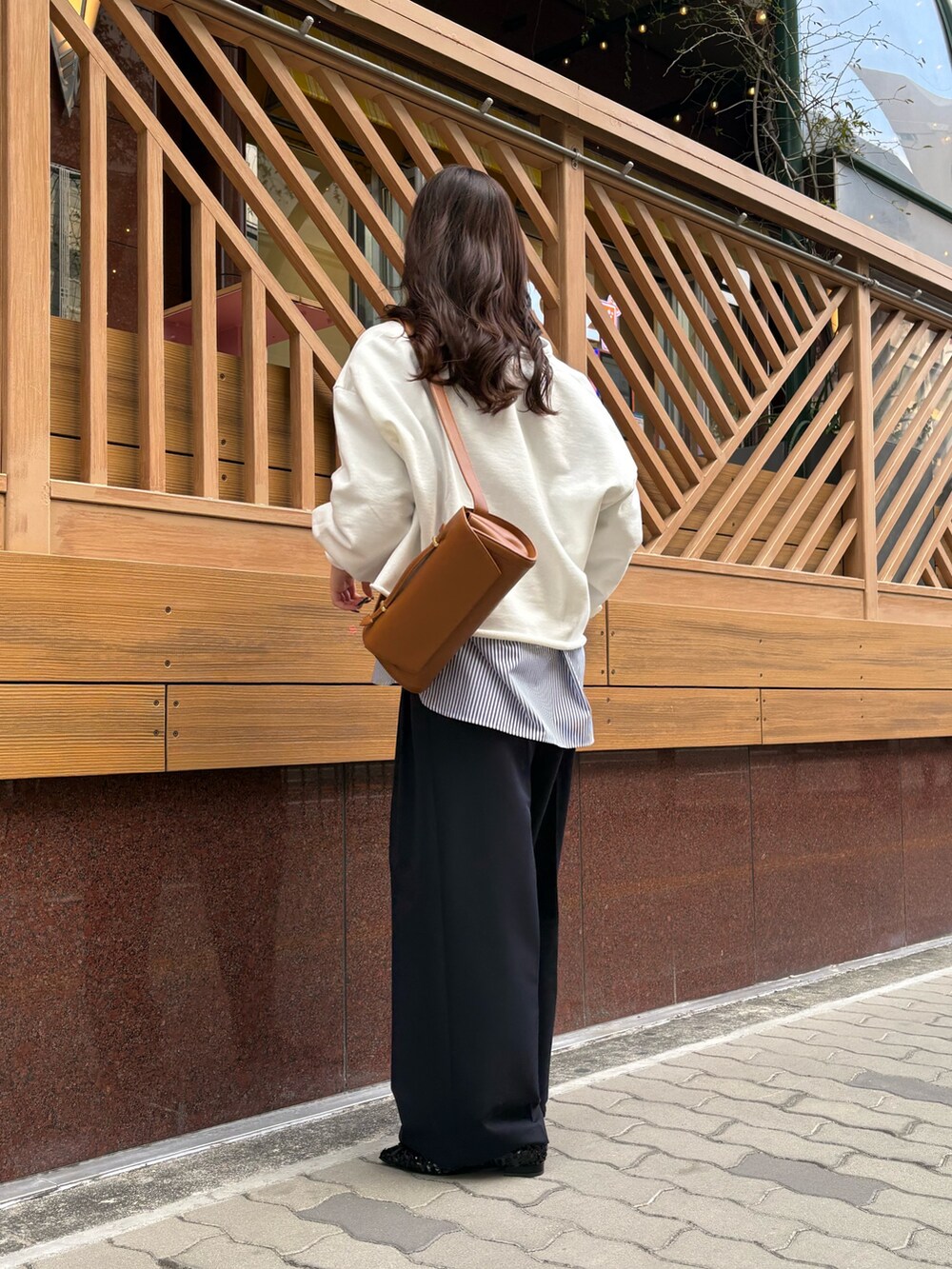 ブルー系のTシャツ/カットソー、ブラウン系のショルダーバッグ、ブルー系のシャツ/ブラウスを着用したレディースの冬コーディネートの2枚目の写真