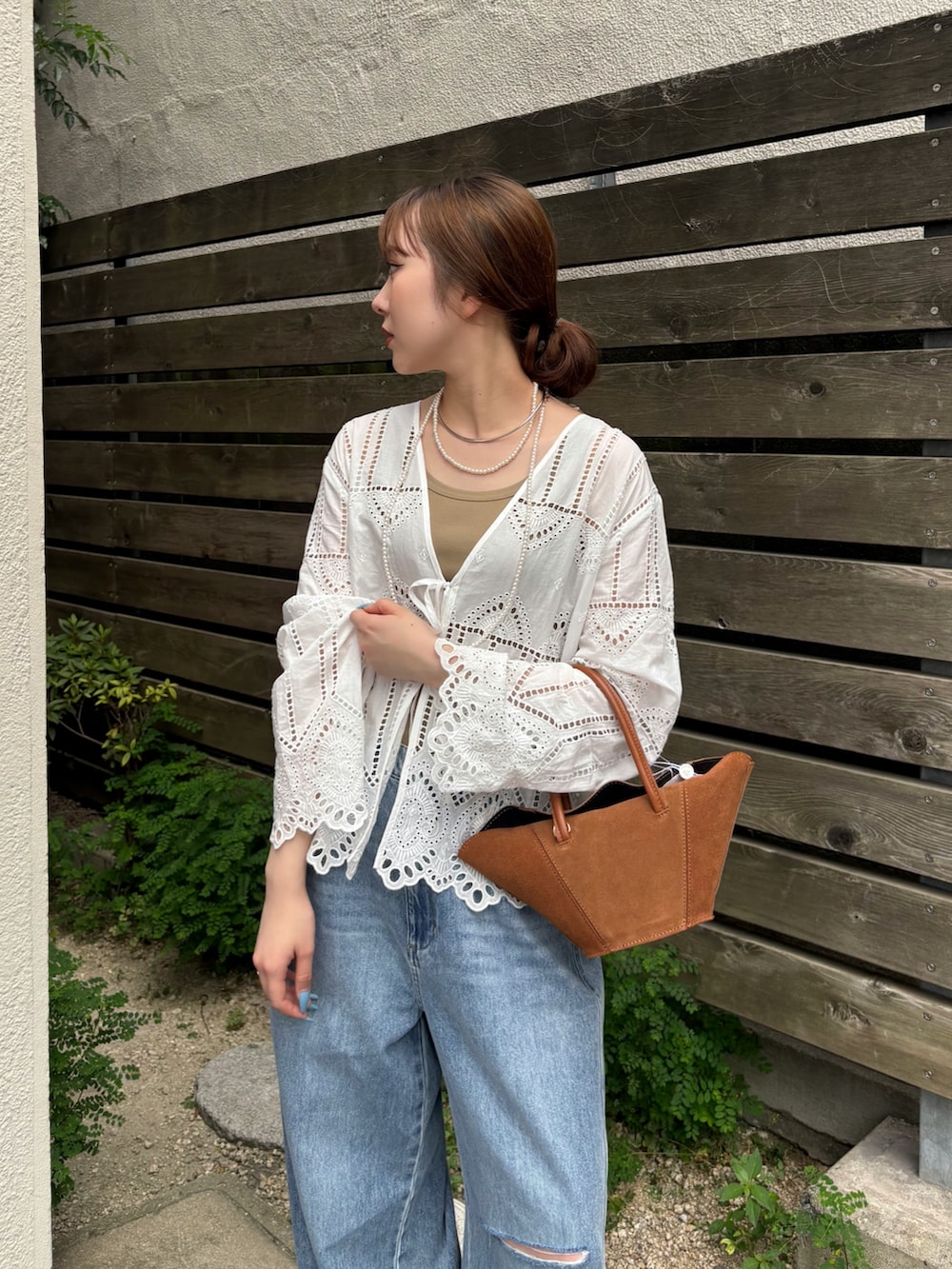 ブルー系のデニムパンツ、ブラック系のサンダル、ホワイト系のシャツ/ブラウスを着用したレディースの夏コーディネートの3枚目の写真
