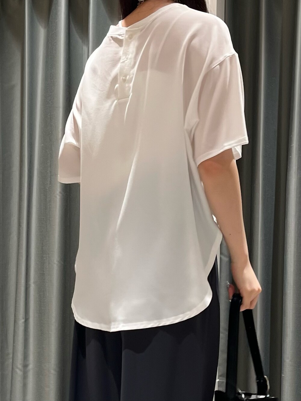 グレー系のスラックス、ブラック系のバッグ、シルバー系のパンプスを着用したレディースの夏コーディネートの5枚目の写真