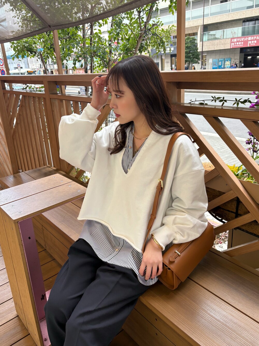 ブルー系のTシャツ/カットソー、ブラウン系のショルダーバッグ、ブルー系のシャツ/ブラウスを着用したレディースの冬コーディネートの3枚目の写真