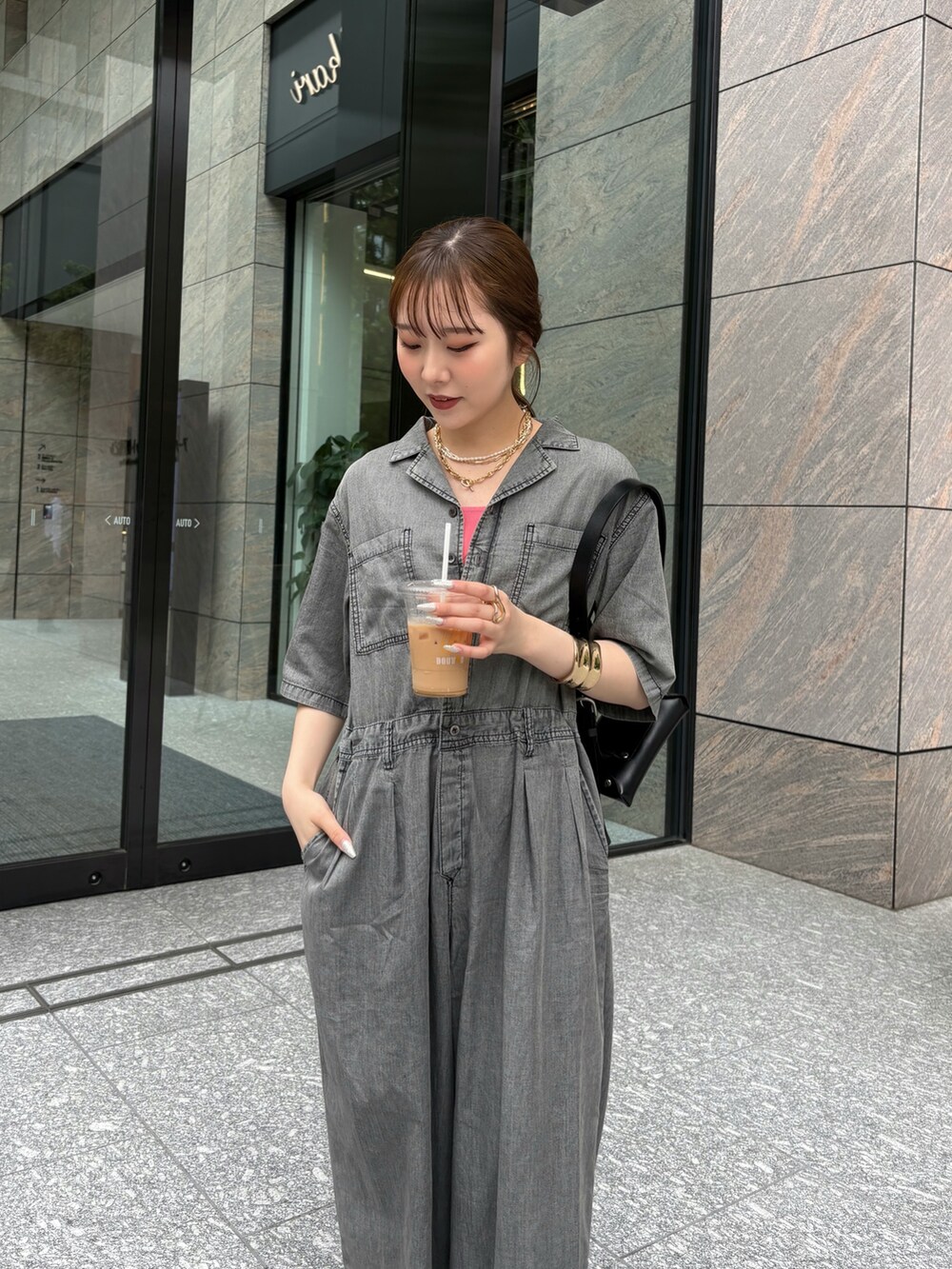 ブラック系のつなぎ/オールインワン、ブラック系のショルダーバッグ、ピンク系のタンクトップを着用したレディースの夏コーディネートの2枚目の写真