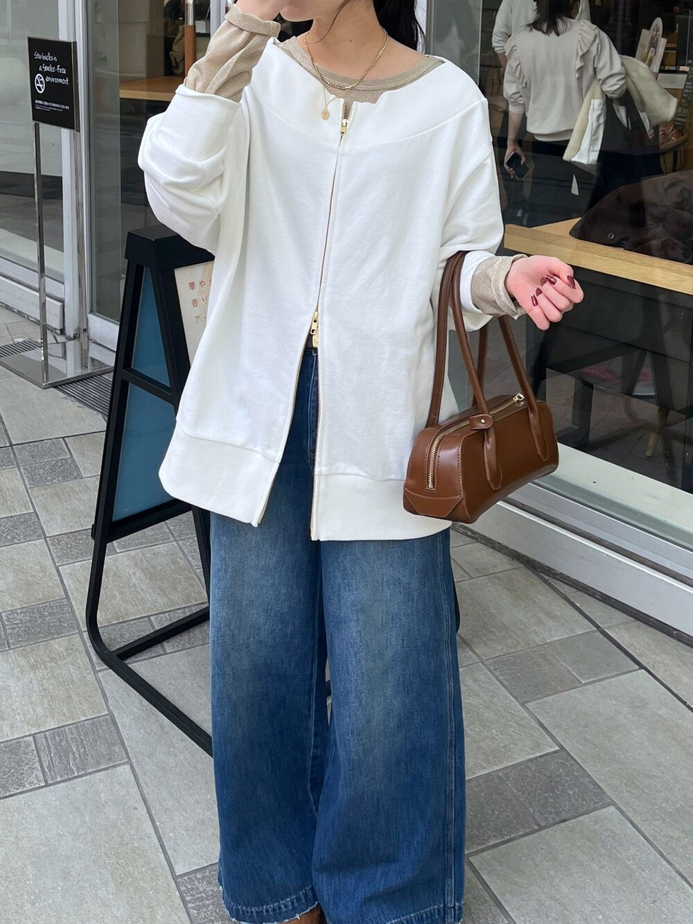 ブルー系のデニムパンツ、ベージュ系のその他アウター、ホワイト系のTシャツ/カットソーを着用したレディースの冬コーディネートの7枚目の写真