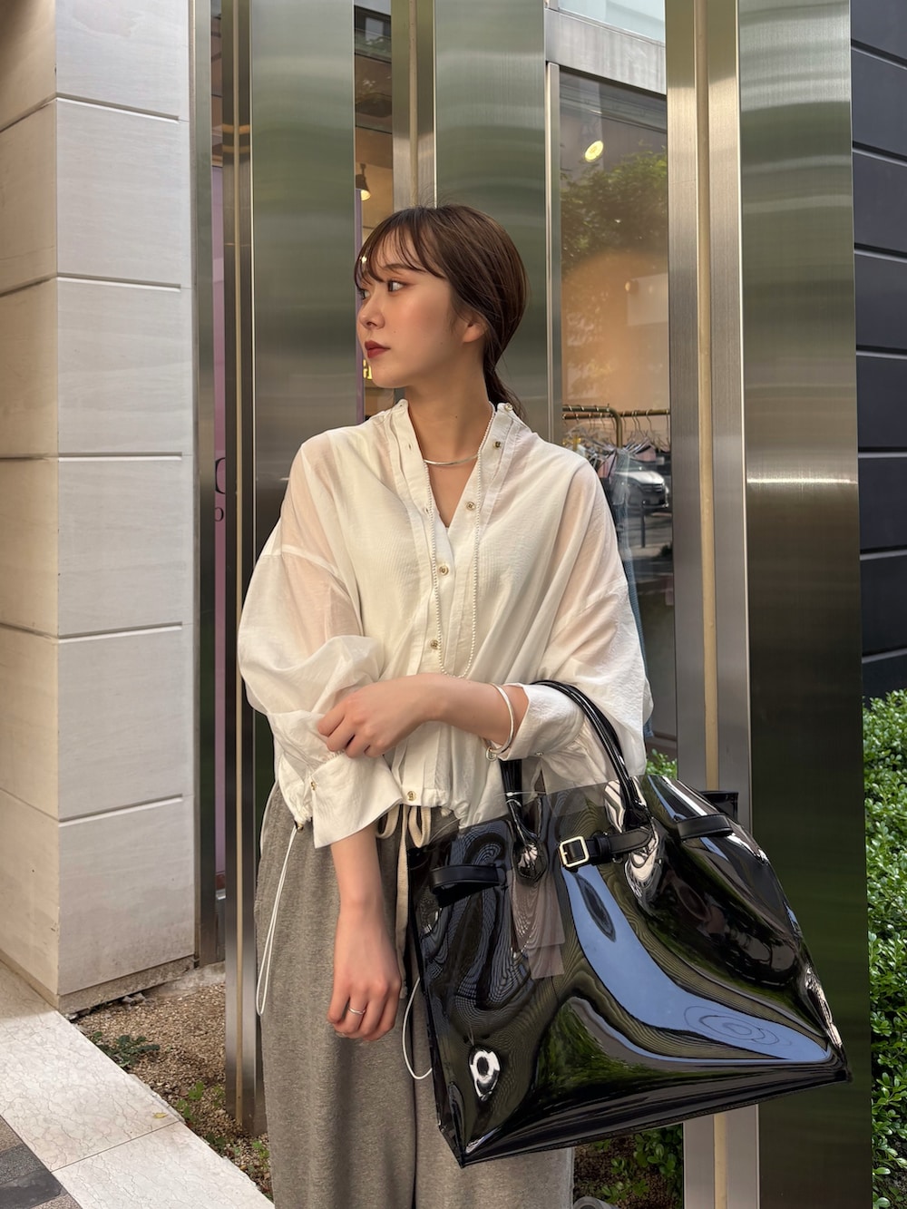 グレー系のその他パンツ、ブラック系のショルダーバッグ、ホワイト系のシャツ/ブラウスを着用したレディースの春コーディネートの6枚目の写真