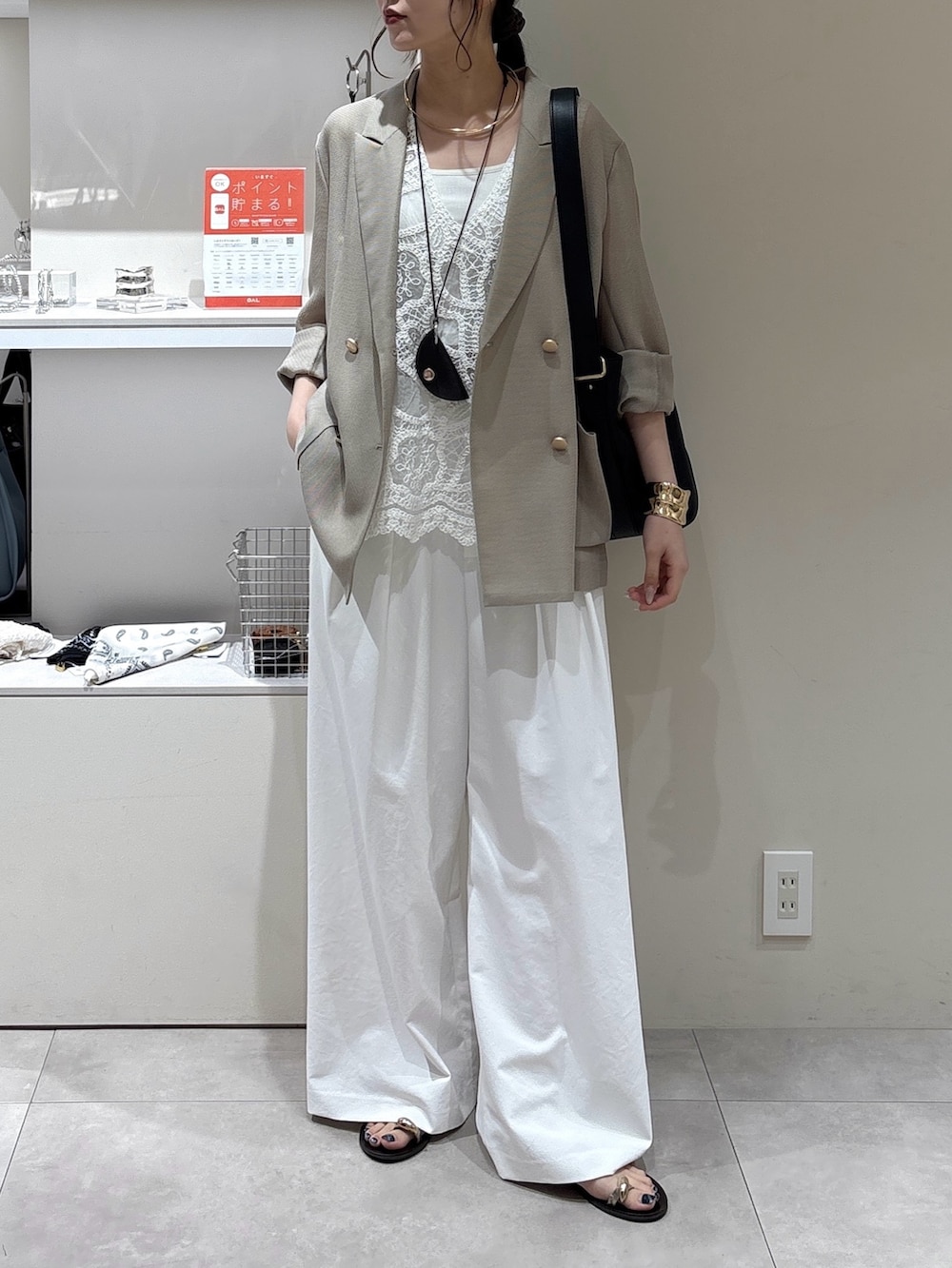 ホワイト系のその他パンツ、ブラック系のショルダーバッグ、ベージュ系のテーラードジャケットを着用したレディースの夏コーディネートの2枚目の写真