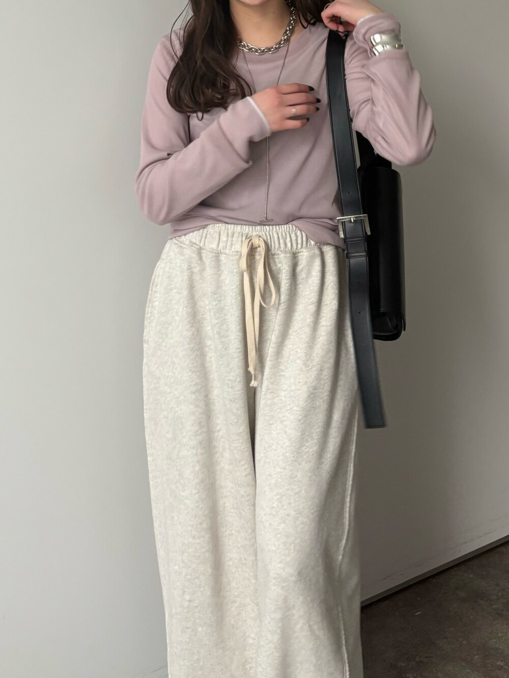 グレー系のその他パンツ、グレー系のTシャツ/カットソー、シルバー系のネックレスを着用したレディースの冬コーディネートの6枚目の写真