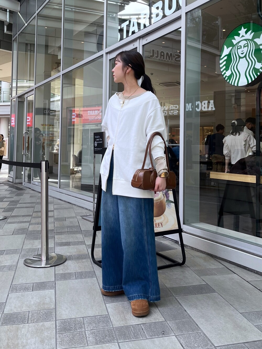 ブルー系のデニムパンツ、ベージュ系のその他アウター、ホワイト系のTシャツ/カットソーを着用したレディースの冬コーディネートの4枚目の写真