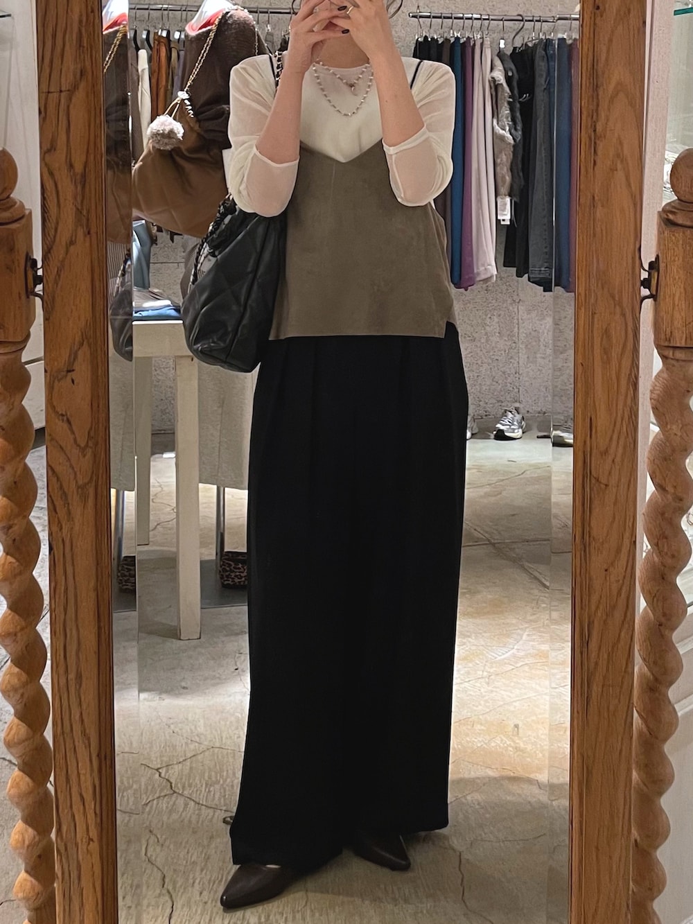 ブラウン系のシャツ/ブラウス、ブラック系のスラックス、ブラウン系のパンプスを着用したレディースの秋コーディネートの2枚目の写真