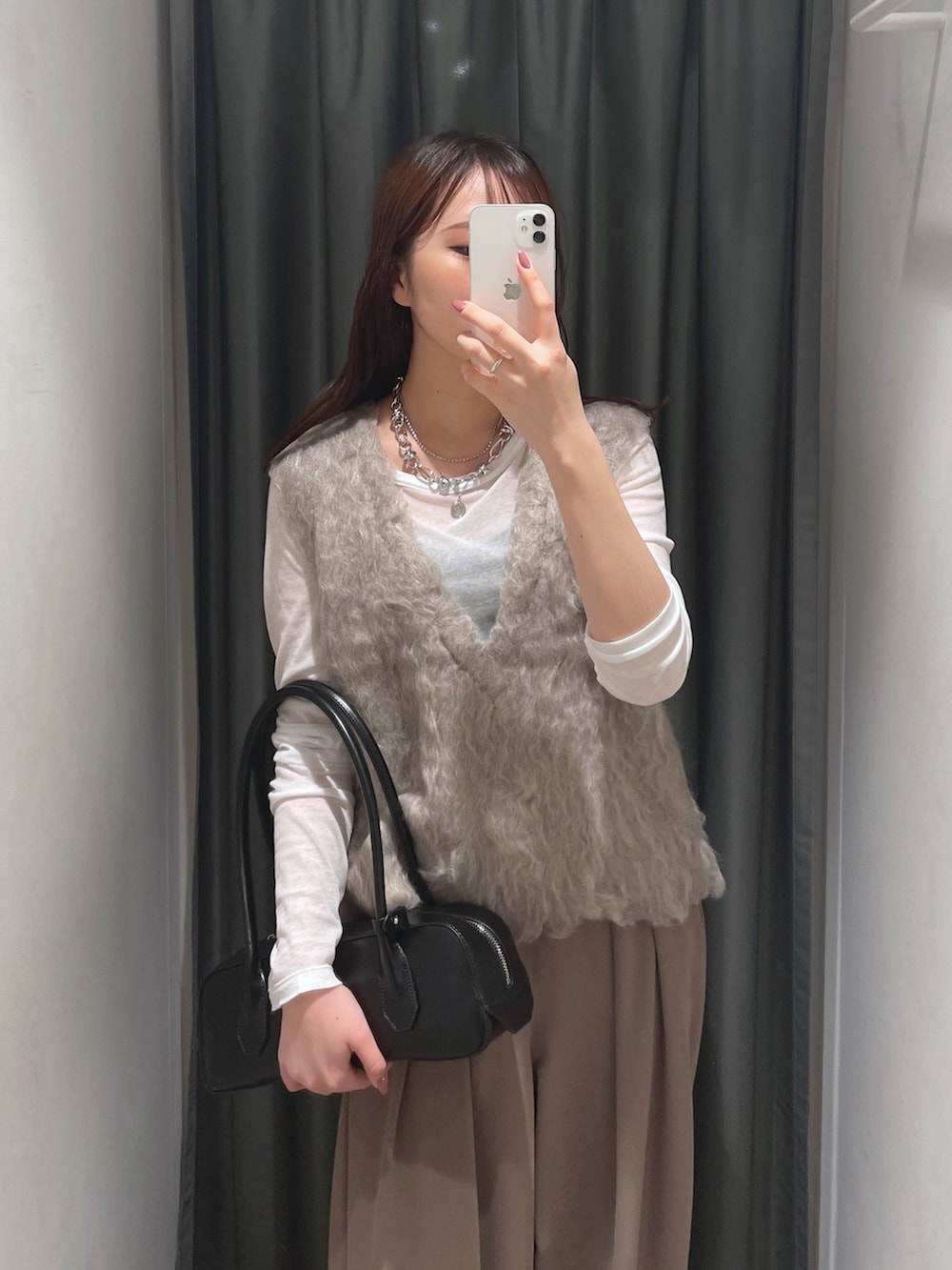 ブラウン系のスラックス、ベージュ系のニット/セーター、ホワイト系のTシャツ/カットソーを着用したレディースの秋コーディネートの4枚目の写真