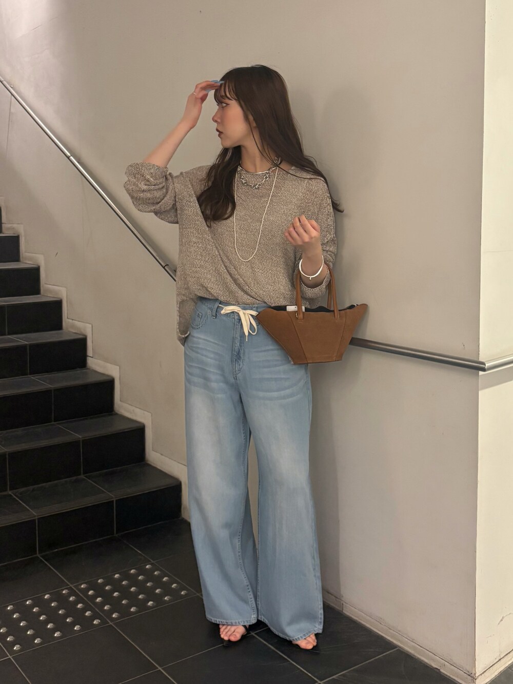 ブルー系のデニムパンツ、ブラック系のサンダル、ベージュ系のニット/セーターを着用したレディースの夏コーディネートの2枚目の写真