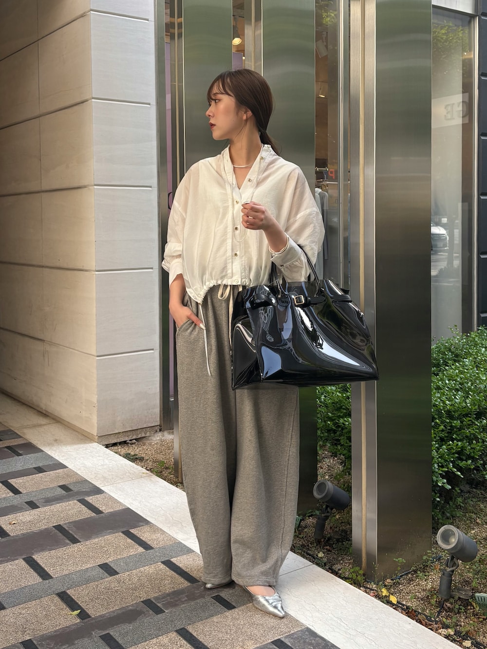 グレー系のその他パンツ、ブラック系のショルダーバッグ、ホワイト系のシャツ/ブラウスを着用したレディースの春コーディネートの5枚目の写真