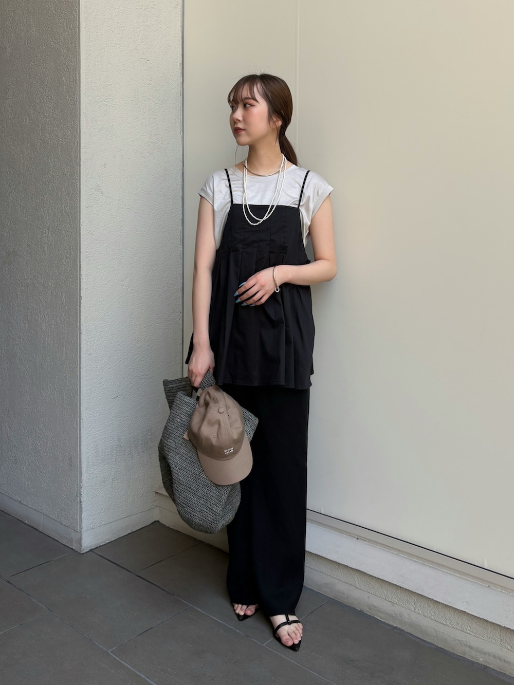 ブラック系のその他パンツ、ブラック系のサンダル、ベージュ系のTシャツ/カットソーを着用したレディースの夏コーディネートの3枚目の写真