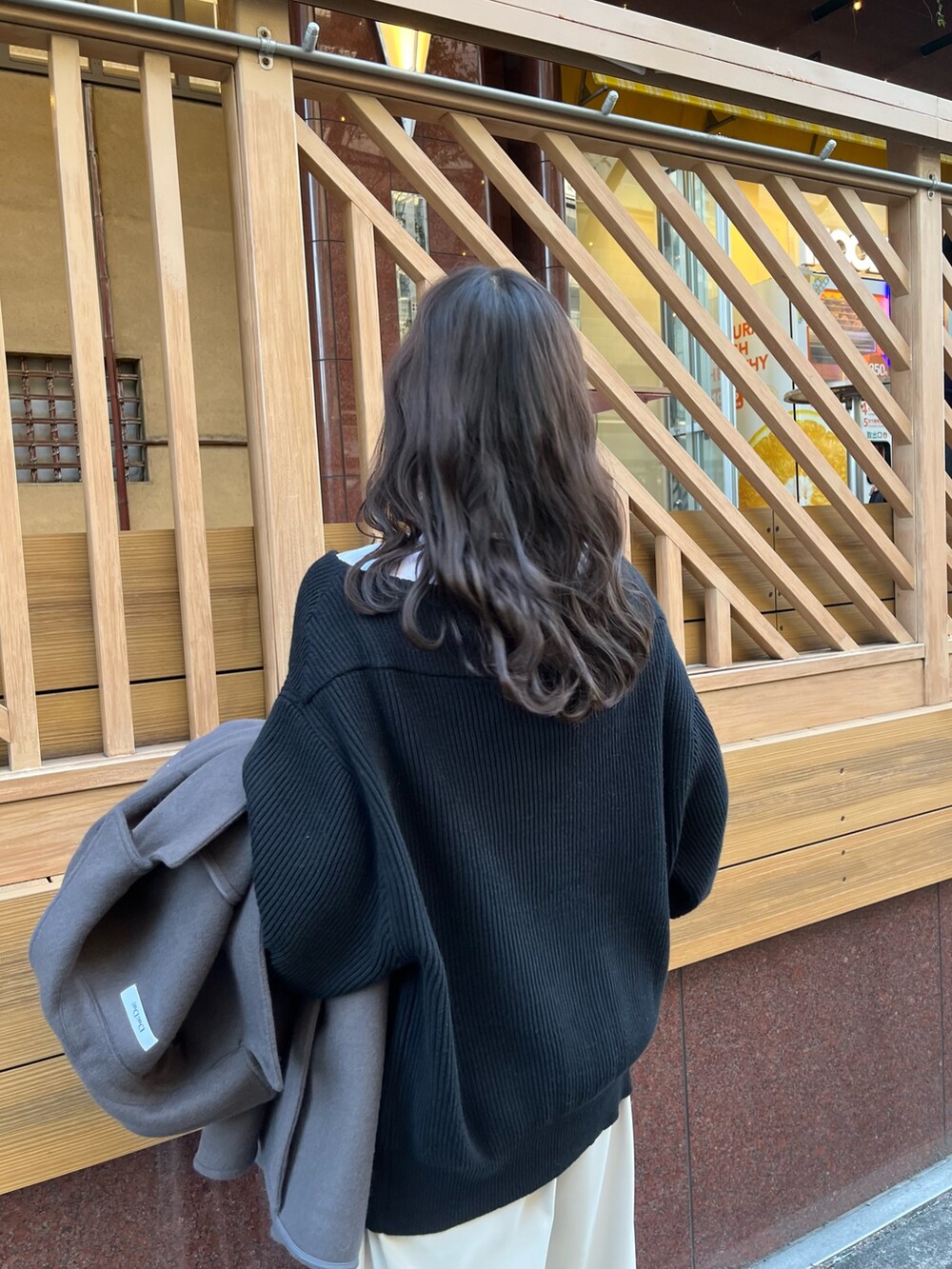 グレー系のスラックス、ブラック系のニット/セーター、ホワイト系のTシャツ/カットソーを着用したレディースの冬コーディネートの3枚目の写真