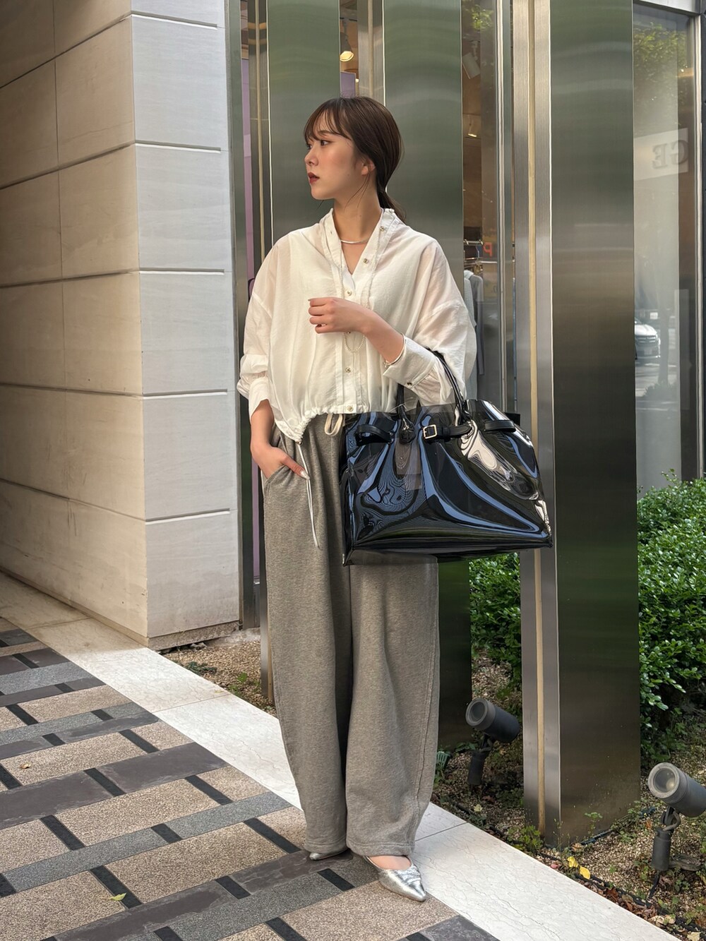 グレー系のその他パンツ、ブラック系のショルダーバッグ、ホワイト系のシャツ/ブラウスを着用したレディースの春コーディネートの2枚目の写真