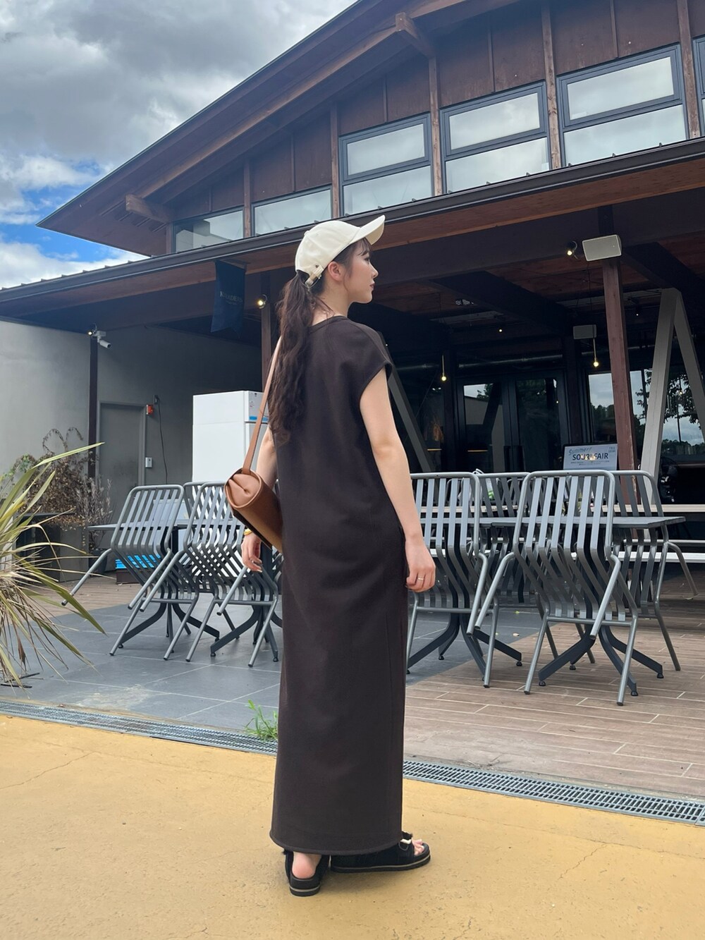 ブラウン系のワンピース、ブラック系のシューズ、ブラウン系のショルダーバッグを着用したレディースの秋コーディネートの2枚目の写真