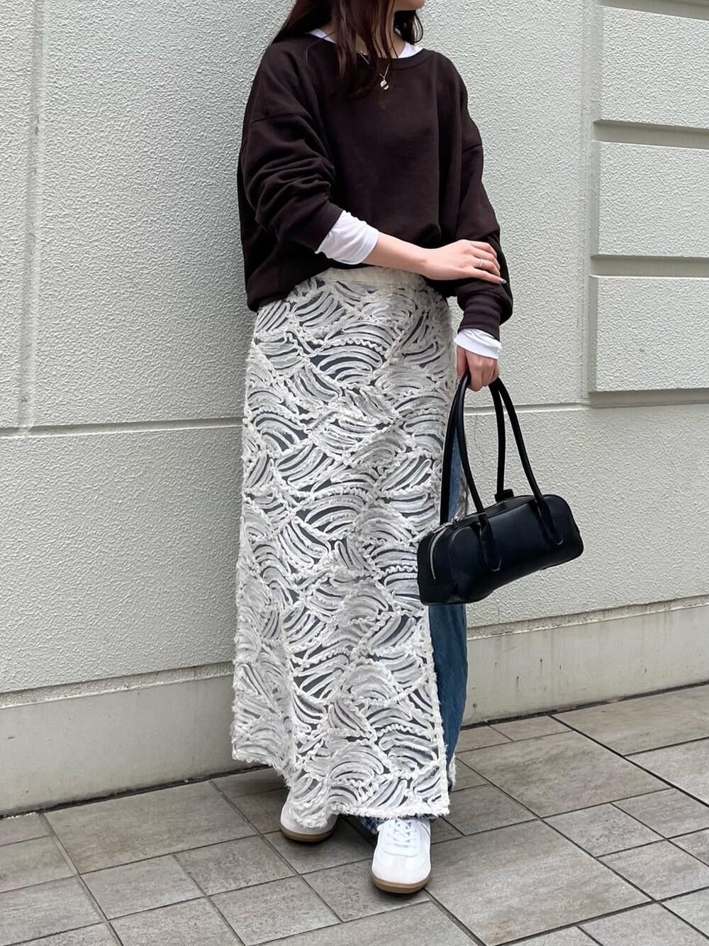 ブラウン系のスウェット、ホワイト系のTシャツ/カットソー、ブラック系のショルダーバッグを着用したレディースの秋コーディネートの2枚目の写真