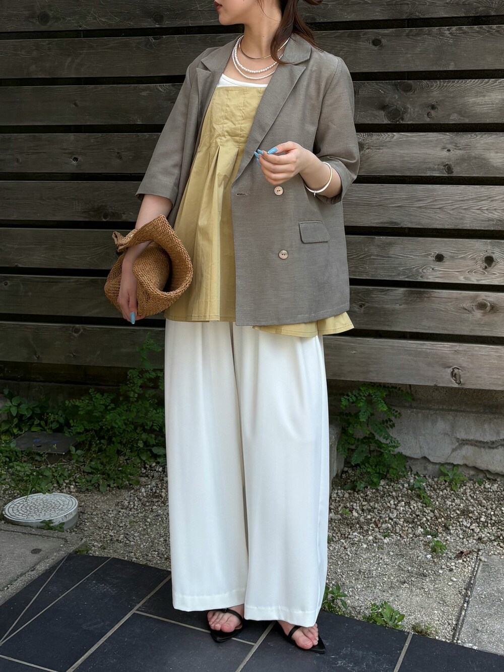 ホワイト系のスラックス、ブラック系のサンダル、ベージュ系のシャツ/ブラウスを着用したレディースの夏コーディネートの4枚目の写真