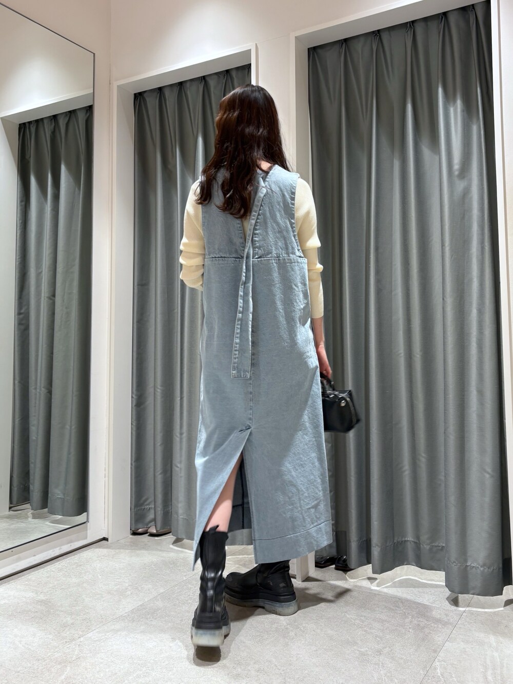 ブルー系のワンピース、ブラック系のショルダーバッグ、ホワイト系のニット/セーターを着用したレディースの冬コーディネートの2枚目の写真