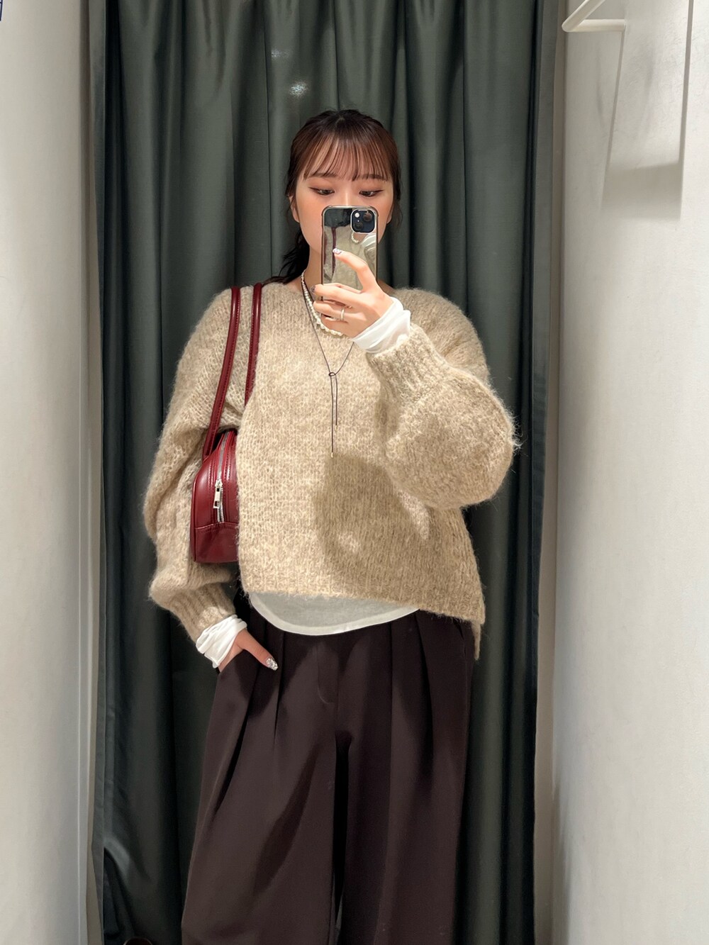 ブラウン系のスラックス、ホワイト系のスニーカー、ホワイト系のTシャツ/カットソーを着用したレディースの秋コーディネートの3枚目の写真