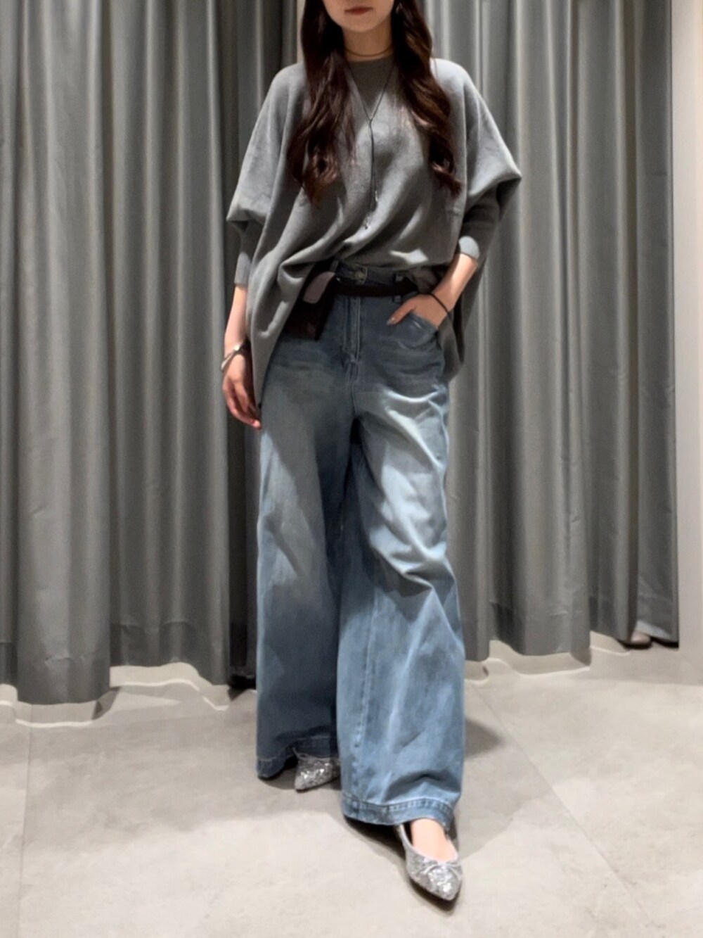 ブルー系のデニムパンツ、シルバー系のパンプス、ブラウン系のショルダーバッグを着用したレディースの秋コーディネートの3枚目の写真