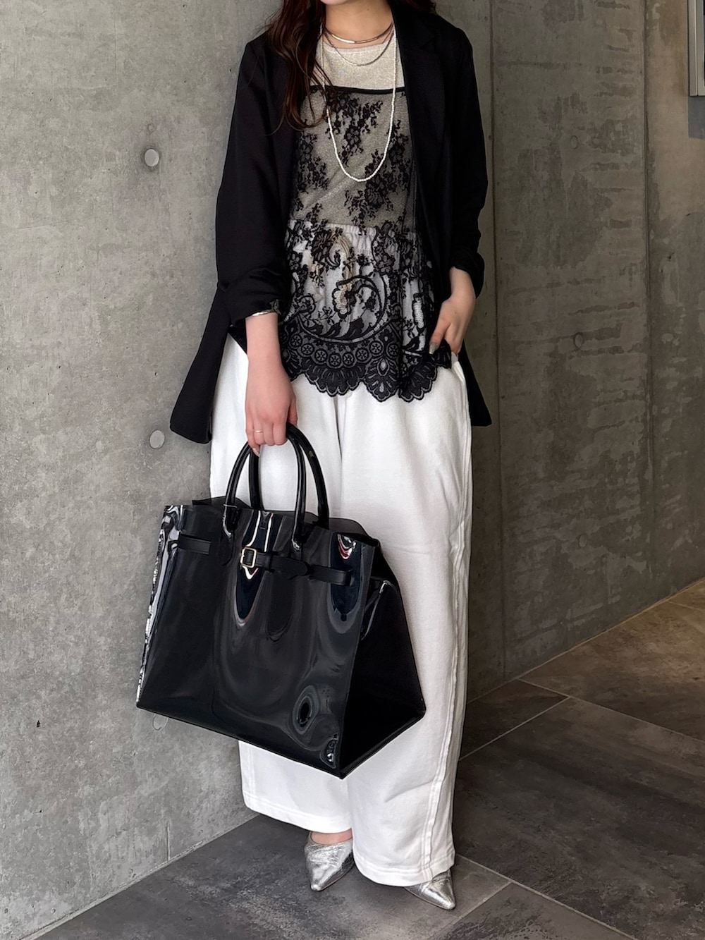 ブラック系のシャツ/ブラウス、ベージュ系のニット/セーター、ブラック系のテーラードジャケットを着用したレディースの春コーディネートの3枚目の写真